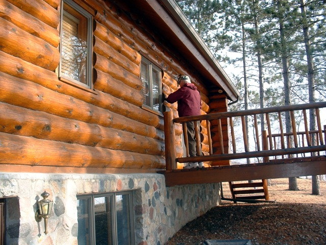Log home that looks dull due to stain wearing thin in places.