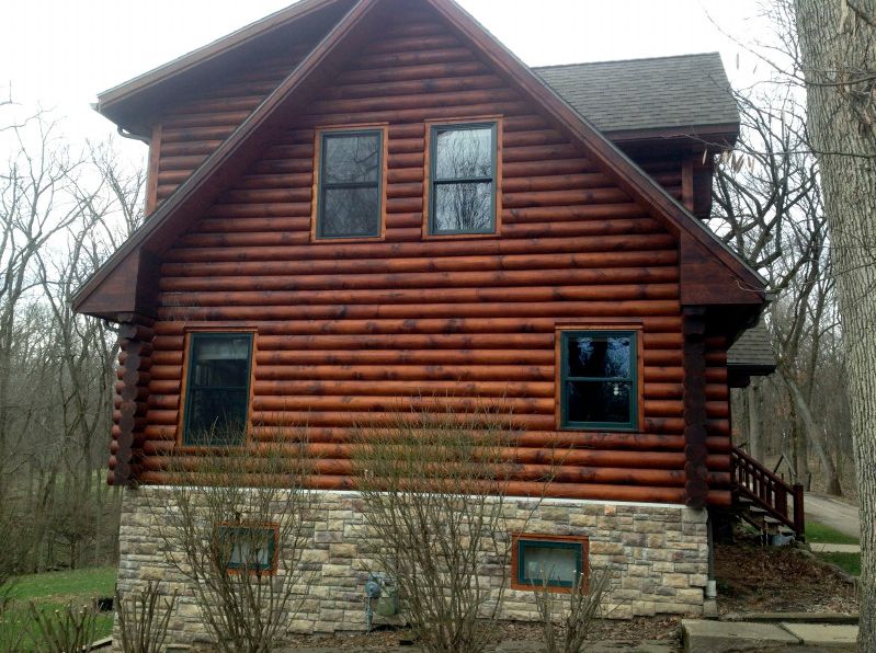 Log home with dark stain patches